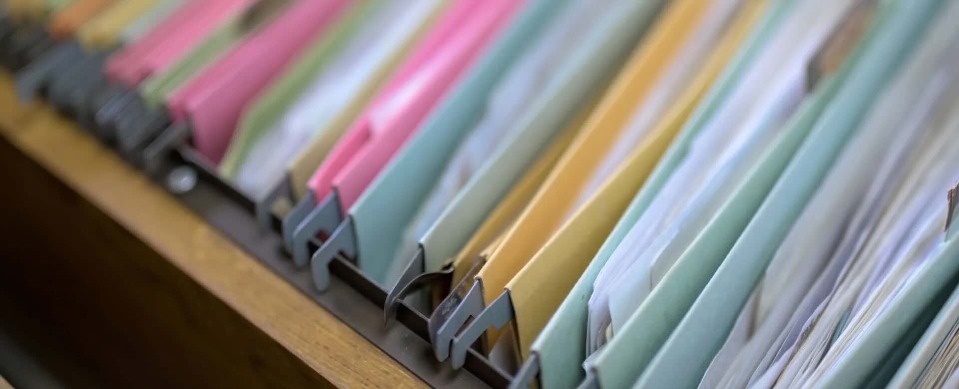 Close up of colourful file folders filled with paper